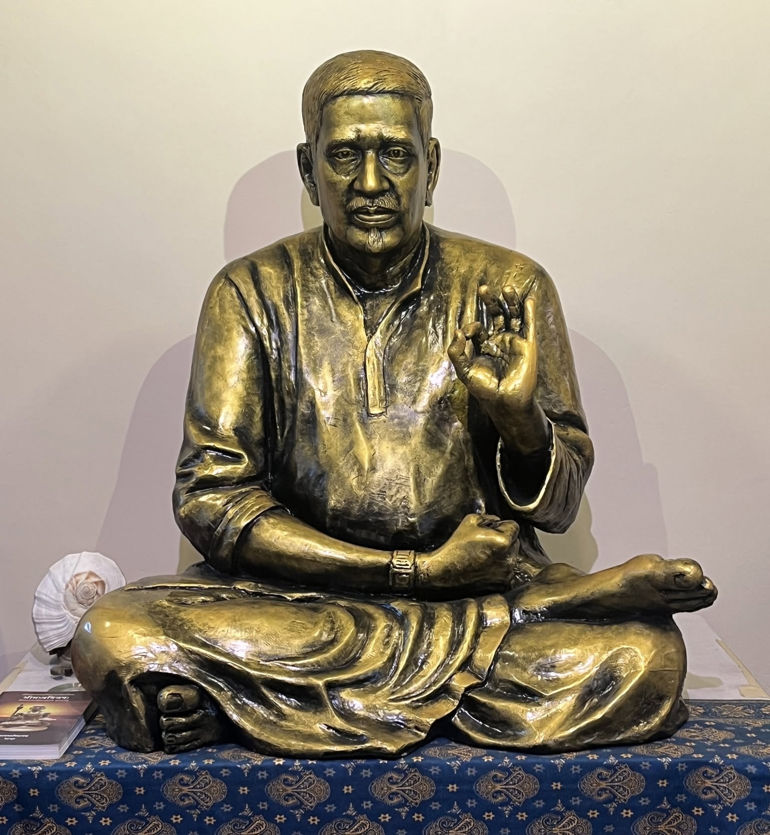 Bronze statue of the revered Guru seated in a meditative posture with a raised blessing gesture.